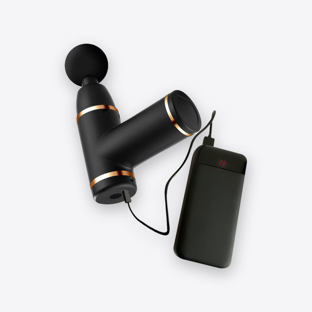 Mini massage gun charging from a power bank via USB-C